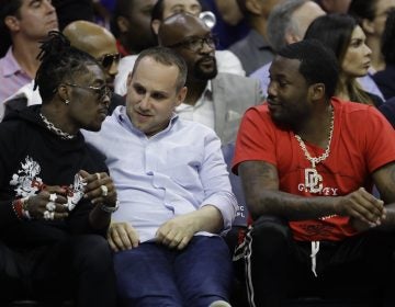 In this May 7, 2018 photo, Philadelphia 76ers' co-owner Michael Rubin, center, talks with rappers Lil Uzi Vert, left, and Meek Mill during the first half of Game 4 of an NBA basketball second-round playoff series against the Boston Celtics in Philadelphia. (AP Photo/Matt Slocum)