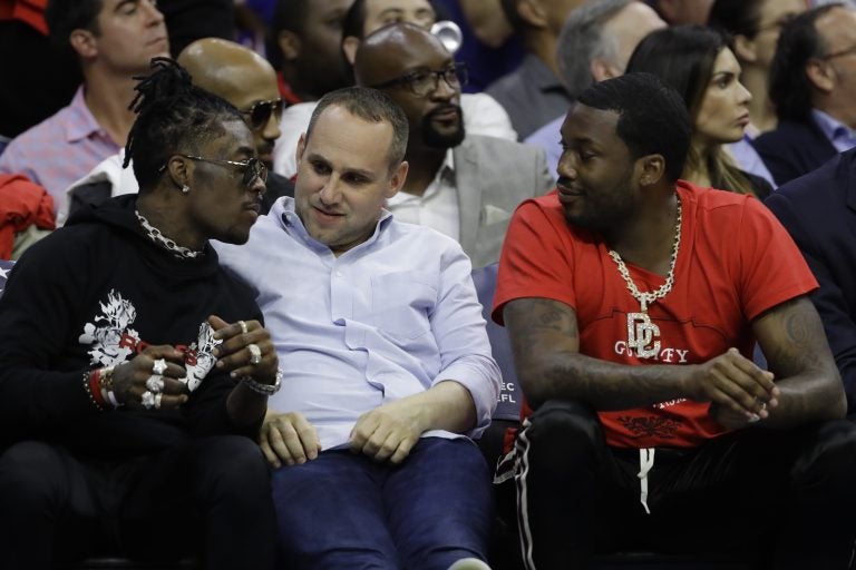 In this May 7, 2018 photo, Philadelphia 76ers' co-owner Michael Rubin, center, talks with rappers Lil Uzi Vert, left, and Meek Mill during the first half of Game 4 of an NBA basketball second-round playoff series against the Boston Celtics in Philadelphia. (AP Photo/Matt Slocum)