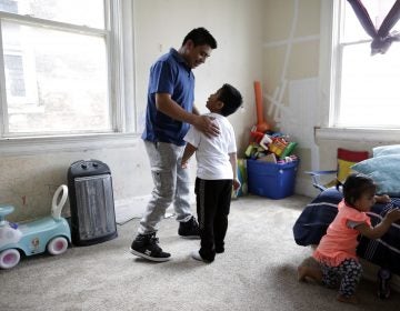 Edgar Perez Ramirez, left, stands with his 4-year-old son, Franco, in their home in Covington, Ky., on April 28, 2018. Perez left San Marcos, Guatemala, for Kentucky after his father was killed. He was heading to work when agents stopped and arrested him in December. (AP Photo/Gregory Bull)