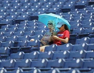 Fans find shade under an umbrella before the start of the Philadelphia Phillies versus the Washington Nationals baseball game, Sunday, July 1, 2018, in Philadelphia. (Laurence Kesterson/AP Photo)