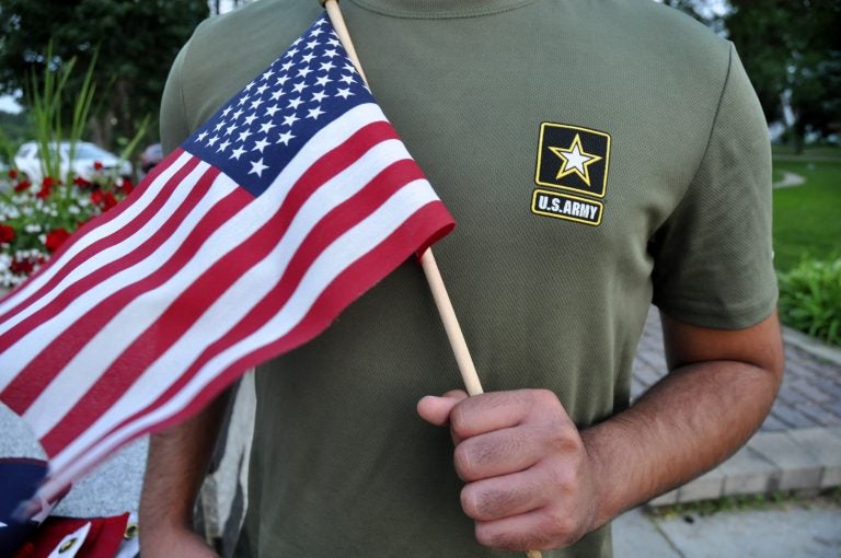 A Pakistani recruit, 22, who was recently discharged from the U.S. Army, holds an American flag as he poses for a picture. The man asked his name and location to be undisclosed for safety reasons. The AP interviewed three recruits from Brazil, Pakistan and Iran, all of whom said they were devastated by their unexpected discharges. (AP Photo/Mike Knaak)