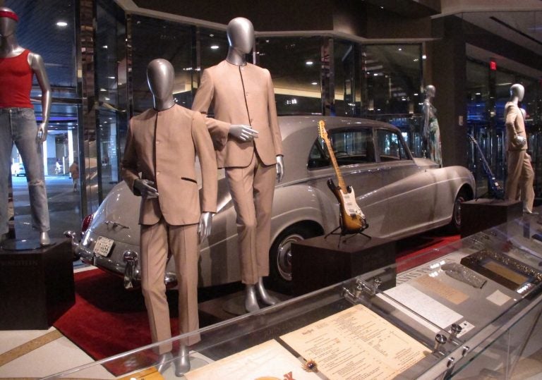 This July 5, 3018 photo shows suits worn by the Beatles during an early tour of America in front of the Rolls Royce automobile owned by Elvis Presley, part of a large collection of music memorabilia on display at the Hard Rock casino in Atlantic City, N.J. (Wayne Parry/AP Photo)