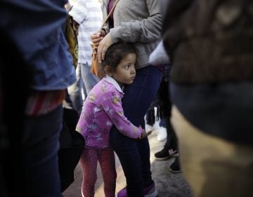 In this June 13, 2018 file photo, Nicole Hernandez, of the Mexican state of Guerrero, holds on to her mother as they wait with other families to request political asylum in the United States, across the border in Tijuana, Mexico. he separation of families at the U.S.-Mexico border caught the attention of the world and prompted mass outrage, but it only tells a small part of the story surrounding the Trump administration’s immigration policy. (Gregory Bull/AP Photo, file)