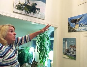 Former Department of Correction counselor Patricia May describes some of the many paintings by Delaware prison inmates that decorate her home in Hockessin, Del., Monday, July 16, 2018. May, a state corrections counselor who was taken hostage during a deadly riot at Delaware's maximum-security prison, says prison officials are to blame. (AP Photo/Randall Chase)