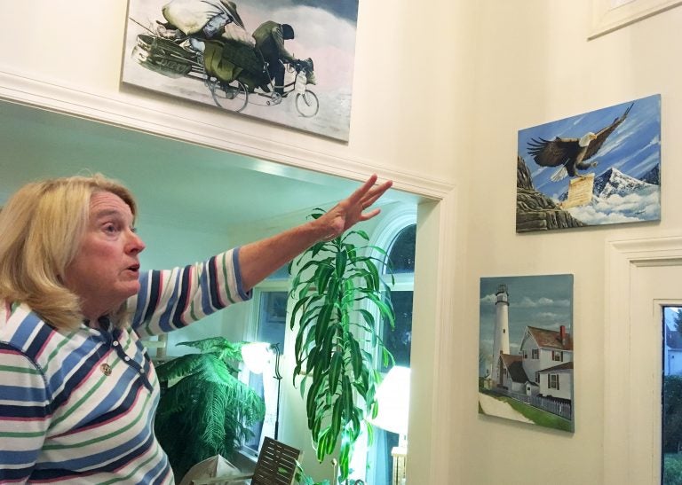 Former Department of Correction counselor Patricia May describes some of the many paintings by Delaware prison inmates that decorate her home in Hockessin, Del., Monday, July 16, 2018. May, a state corrections counselor who was taken hostage during a deadly riot at Delaware's maximum-security prison, says prison officials are to blame. (AP Photo/Randall Chase)