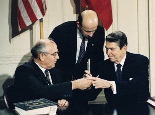 In this Dec. 8, 1987 file photo U.S. President Ronald Reagan, (right), and Soviet leader Mikhail Gorbachev exchange pens during the Intermediate Range Nuclear Forces Treaty signing ceremony in the White House East Room in Washington, D.C. Gorbachev's translator Pavel Palazhchenko stands in the middle. Pavel Palazhchenko was a constant presence as chief interpreter for Soviet leader Mikhail Gorbachev and Foreign Minister Eduard Shevardnadze, and watched from Moscow to see how the latest chapter in the US-Soviet story would unfold. (Bob Daugherty/AP Photo, File)