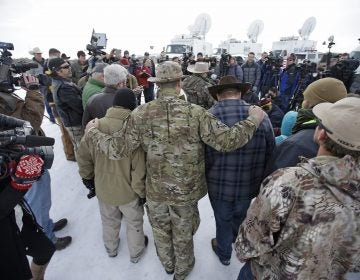 Members of the group occupying the Malheur National Wildlife Refuge headquarters hug after Ammon Bundy, center, left, one of the sons of Nevada rancher Cliven Bundy, spoke with reporters during a news conference Monday, Jan. 4, 2016, near Burns, Ore. The group calls itself Citizens for Constitutional Freedom and has sent a 