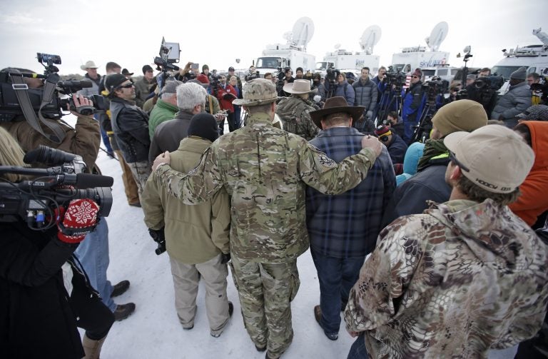 Members of the group occupying the Malheur National Wildlife Refuge headquarters hug after Ammon Bundy, center, left, one of the sons of Nevada rancher Cliven Bundy, spoke with reporters during a news conference Monday, Jan. 4, 2016, near Burns, Ore. The group calls itself Citizens for Constitutional Freedom and has sent a 