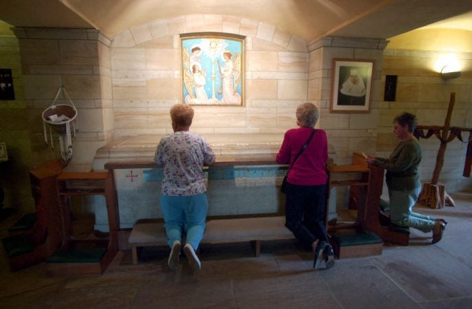 In this Oct. 2, 2000, file photo, worshippers kneel at the crypt of Saint Katharine Drexel at her national shrine on the Sisters of the Blessed Sacrament's suburban Philadelphia estate in Bensalem, Pa. (AP Photo/Dan Loh, File)