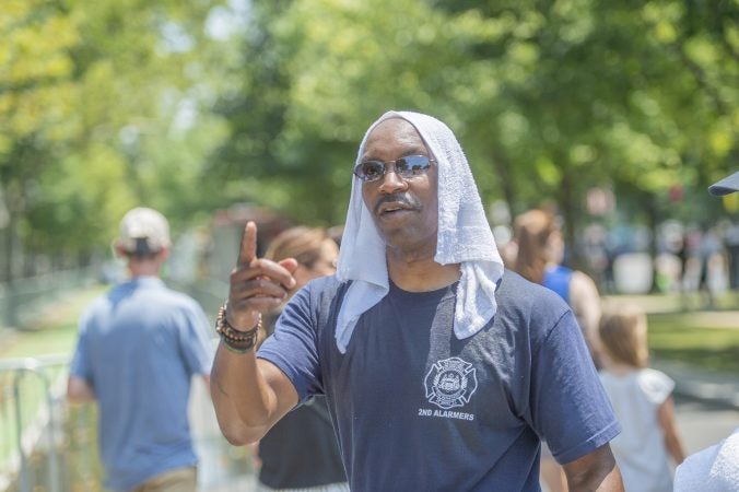 Second Alarmer Darian Thomas handed out water drenched towels to police and other first responders.(Jonathan Wilson for WHYY)