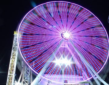 The lights of the Ferris wheel at Playland’s Castaway Cove amusement park are a blur. Motorists coming over the Ninth Street Causeway can watch these and the lights of the Gillian’s Wonderland Ferris wheel change and spin as they head into town. (Bill Barlow/for WHYY)