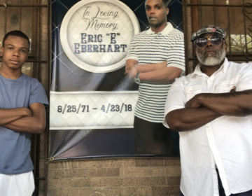 Eric Eberhart, 17, left, stands next to Shawn Wilson in front of a picture of his father, Eric Eberhart Sr., who was gunned down earlier this year. — Tribune Photo by John Mitchell