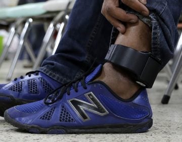 An immigrant wears an ankle monitor as he sits at a shelter in McAllen, Texas after he was released after processing by U.S. Customs and Border Protection. (Eric Gay/AP)