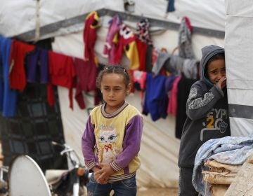 Syrian refugee girls stand outside their tent at a camp near the border with Syria in eastern Lebanon on June 13. (Hussein Malla/AP)