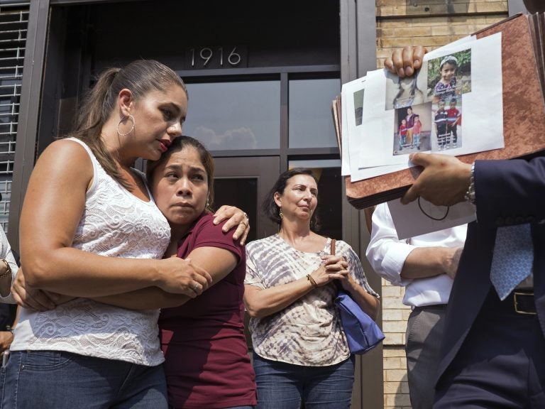 Yeni Gonzalez (center), a Guatemalan mother who was separated from her three children at the U.S.-Mexico border, is embraced by volunteer Janey Pearl Starks as pictures of other children separated from their families are displayed during a news conference on Tuesday in New York City. Gonzalez saw her children in a New York City facility for the first time since mid-May. (Craig Ruttle/AP)