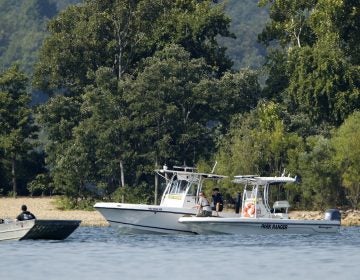 Emergency workers patrol an area of Table Rock Lake in Branson, Mo., on Friday, a day after a duck boat capsized and sank during a storm. Authorities say 17 people died in the accident. (Charlie Riedel/AP)