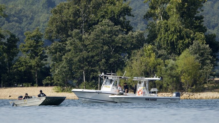 Emergency workers patrol an area of Table Rock Lake in Branson, Mo., on Friday, a day after a duck boat capsized and sank during a storm. Authorities say 17 people died in the accident. (Charlie Riedel/AP)