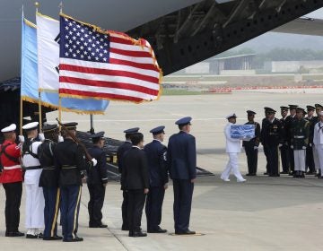 A U.N. honor guard carries a box containing remains believed to be from American servicemen killed during the 1950-53 Korean War after arriving from North Korea, at Osan Air Base in Pyeongtaek, South Korea on Friday. (Ahn Young-joon/AP)