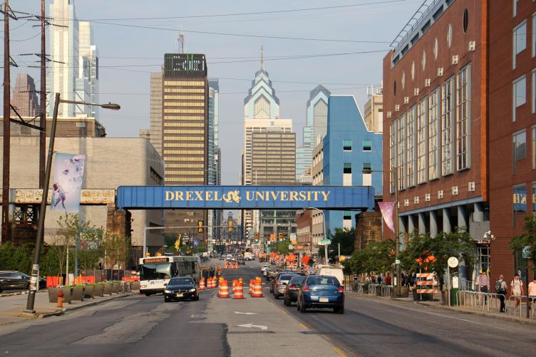 A sign reads Drexel University. The Philadelphia skyline is visible behind it.