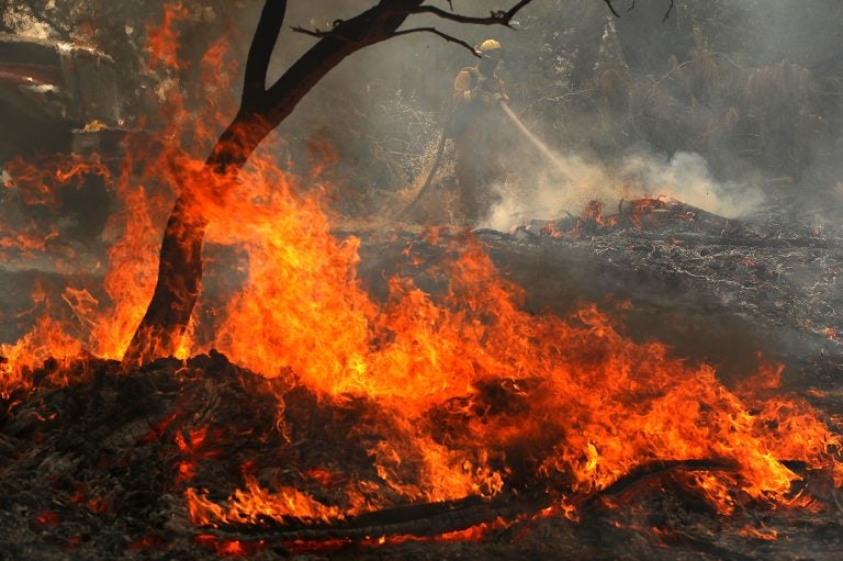 A Cal Fire firefighter mops up hot spots after the Carr Fire moved through the area on Saturday in Redding, Calif. The fire is 5 percent contained. (Justin Sullivan/Getty Images)