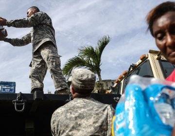 U.S. Army soldiers pass out water, provided by FEMA, to residents in a neighborhood without grid electricity or running water in San Isidro, Puerto Rico, on Oct. 17, 2017. (Mario Tama/Getty Images)