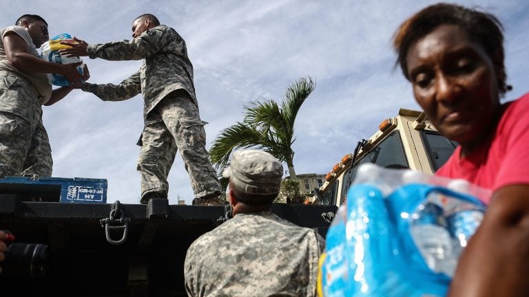 U.S. Army soldiers pass out water, provided by FEMA, to residents in a neighborhood without grid electricity or running water in San Isidro, Puerto Rico, on Oct. 17, 2017. (Mario Tama/Getty Images)