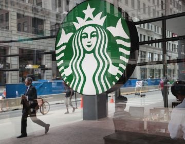 People walk by a Starbucks store in Chicago on May 29. Starbucks announced it plans on removing plastic straws from its 28,000 stores worldwide by 2020.