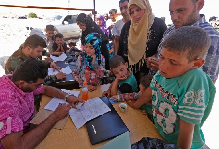 Syrian refugees gather in their vehicles as they get ready to cross into Syria from the eastern Lebanese border town of Arsal on Thursday. More than 400 Syrians were registered to make the crossing on Thursday, after having requested permission from the Lebanese and Syrian governments. (Bilal Hussein/AP)