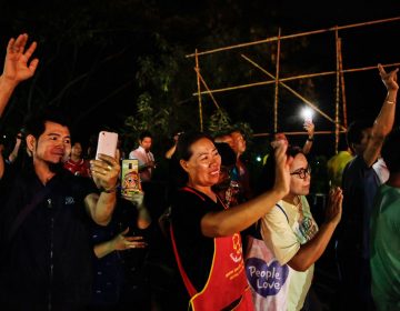 Onlookers in Chiang Rai, Thailand, watch and cheer as ambulances transport some of the rescued schoolboys from a cave where they were trapped for two weeks.