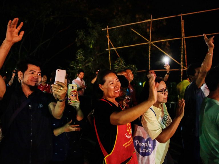 Onlookers in Chiang Rai, Thailand, watch and cheer as ambulances transport some of the rescued schoolboys from a cave where they were trapped for two weeks.