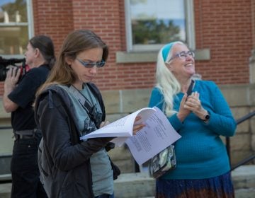 Elise Gerhart (left) reads a 2017 ruling about the environment from the Pennsylvania Supreme Court outside of the Huntingdon County Courthouse with her mother Ellen. (Lindsay Lazarski/WHYY)