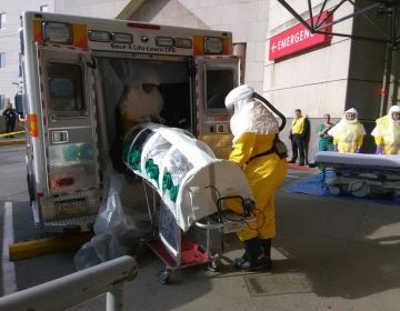EMTs unload Parag S. Gohel from an ambulance at UPMC Presbyterian's ER. Gohel is in an isolation pod because he’s pretending to have an infectious disease for the hospital’s yearly drill. (Sarah Boden/WESA)