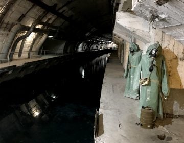 Hazmat suits hang next to the canal that leads from Balaklava Bay to the heart of the underground base. (Lucian Kim/NPR)