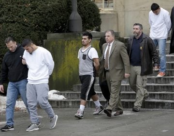 FILE - In this Jan. 11, 2018 file photo, suspected members of the MS-13 gang are escorted to their arraignment in Mineola, N.Y. A sweep of alleged MS-13 gang members on Long Island has racked up impressive arrest totals but also left unanswered questions. Since May, federal authorities say they've arrested more than 220 members of the notorious street gang. But authorities have largely declined multiple requests by for even the most basic information about the arrests. (AP Photo/Seth Wenig, File)