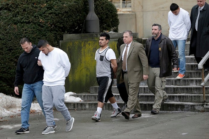 FILE - In this Jan. 11, 2018 file photo, suspected members of the MS-13 gang are escorted to their arraignment in Mineola, N.Y. A sweep of alleged MS-13 gang members on Long Island has racked up impressive arrest totals but also left unanswered questions. Since May, federal authorities say they've arrested more than 220 members of the notorious street gang. But authorities have largely declined multiple requests by for even the most basic information about the arrests. (AP Photo/Seth Wenig, File)