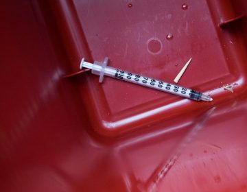 A used syringe is seen in a disposal container. (AP Photo/Mary Altaffer)