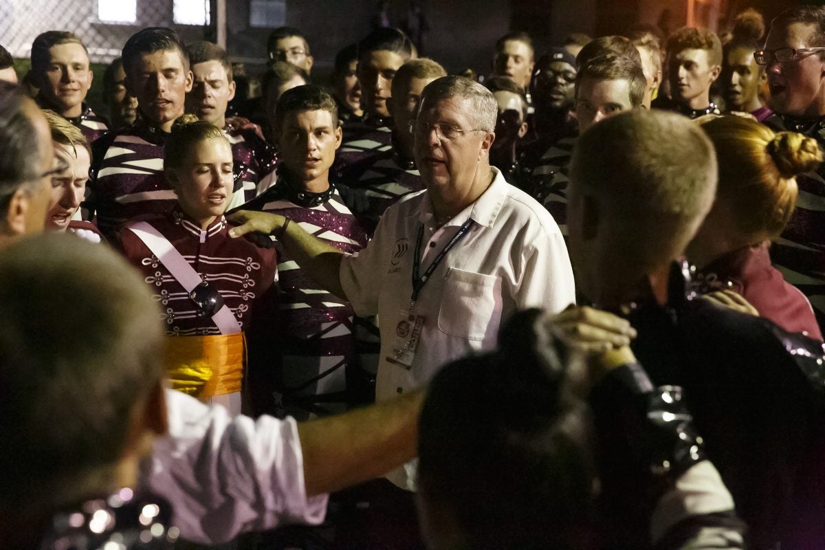 Cadets Director Scott Litzenberg, center, leads the Cadets in the singing of their song, "O Holy Name," before their first home performance of the summer. Litzenberg marched with the Cadets in 1982 and 1983.