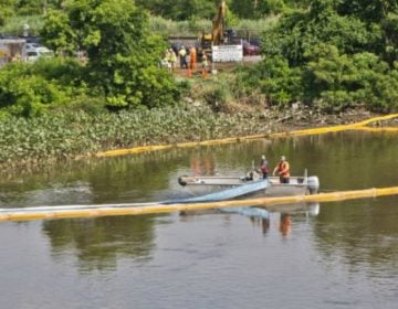 An environmental cleanup crew works to remove fuel from a spill in Darby Creek in Tinicum Township, Pennsylvania, near the Philadelphia International Airport. (Kimberly Paynter/WHYY)