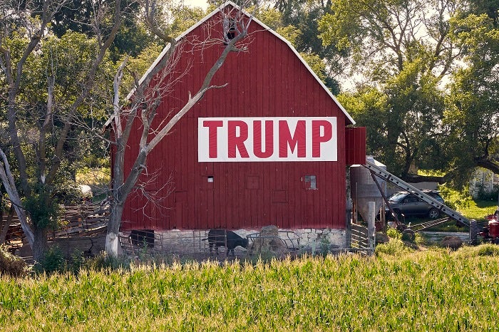 Corn grows in front of a barn carrying a large Trump sign in rural Ashland, Neb., Tuesday, July 24, 2018. The Trump administration announced Tuesday it will provide $12 billion in emergency relief to ease the pain of American farmers slammed by President Donald Trump's escalating trade disputes with China and other countries. (AP Photo/Nati Harnik)