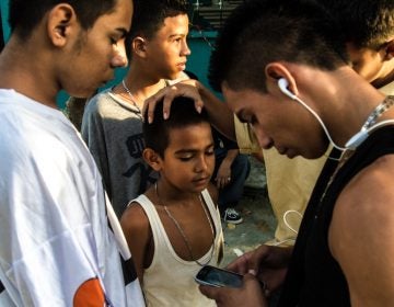 A group of older boys, some of whom are gang members, joke around with a younger boy. Neighborhood children are often groomed for gang activity from the age of 6 or 7. At first they may be given small assignments — like buying snacks for gang members or monitoring who's coming in and out of a neighborhood, says Ayuso. Bit by bit, he says, they graduate into bigger responsibilities. (Tomas Ayuso)
