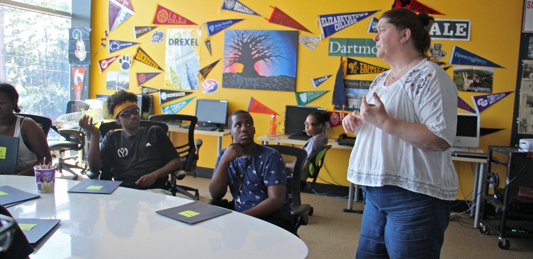 Senior Academic Director Alix Davis Cummin teaches a class on essay writing to high schoolers in the Squash Smarts program. (Emma Lee/WHYY)