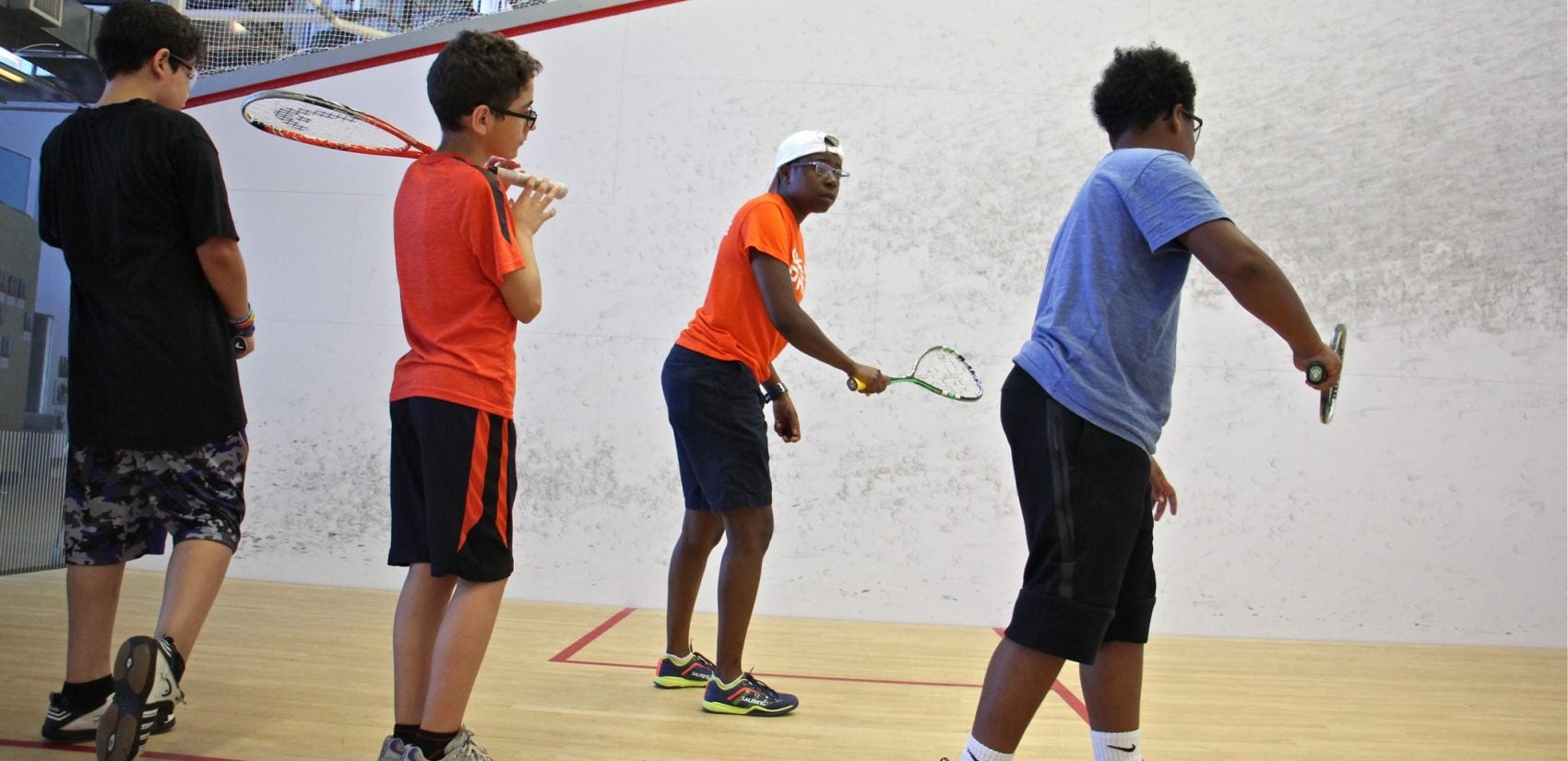 Squash coach Tempest Bowden runs drills with middle schoolers. (Emma Lee/WHYY)