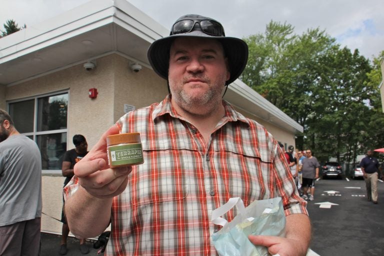 Thom ?? holds a container of dry-leaf marijuana, which was made available for sale at dispensaries in Pennsylvania for the first time. About 50 people lined up outside TerraVida Holistic Centers in Abington hours before the dispensary opened at 10 a.m.