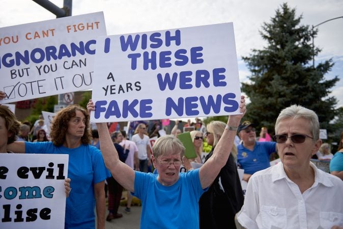 Mary Reddy, 79, of Shavertown, Pa., stands among fellow protesters on Highland Park Boulevard in Wilkes-Barre, Pa. The are participants of an Anti-Trump protest outside of the Make America Great Again rally on August 2, 2018. (Natalie Piserchio for WHYY)