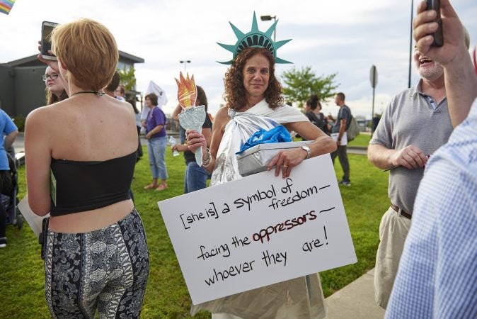 Cindy Malkemes, 57, of Dallas, Pa. dresses as Lady Liberty at an Anti-Trump protest in Wilkes-Barre, Pa., on August 2, 2018. (Natalie Piserchio for WHYY)