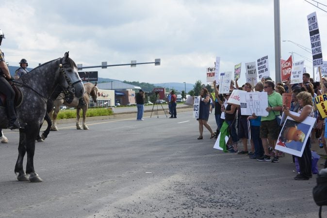 Police on horses gather a crowd of protesters towards the sidewalk on Highland Park Boulevard in Wilkes-Barre, Pa. Approximately 300 protesters showed up on August 2, 2018, outside of the Make America Great Again rally. (Natalie Piserchio for WHYY)