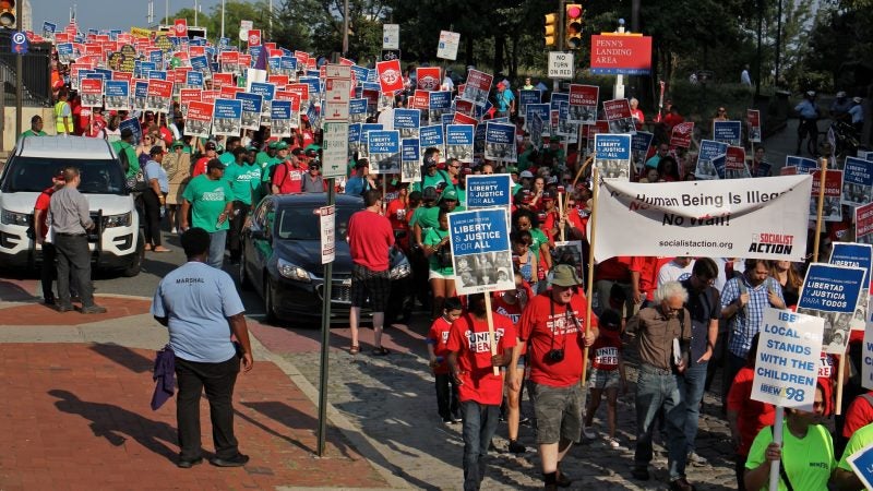 Thousands of union members march silently down Chestnut Street Wednesday in support of immigrant families. (Emma Lee/WHYY)