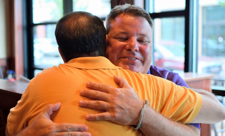 Mayor Peter Ursucheler and developer Manny DeMutis embrace upon meeting at Iron Hill Brewery in Phoenixville, PA, on August 21, 2018. (Bastiaan Slabbers for WHYY)