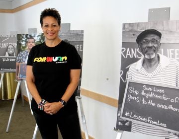 Sara Lomax-Reese, president and CEO of WURD Radio, presides over Founder's Day, which celebrates the legacy of her father, Philadelphia physician and entrepreneur Walter P. Lomax, Jr., who founded the radio station. She stands among posters created for WURD's Transmit/Transform multimedia project aimed at stopping violence.