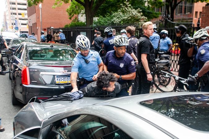 A protestor is arrested by Philadelphia Police during a scuffle that broke out on Race Street between Antifa protestors and the police. (Brad Larrison for WHYY)
